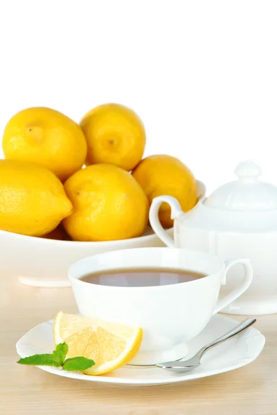 軽い背景でテーブルの上にレモンとお茶のカップ — ストック写真