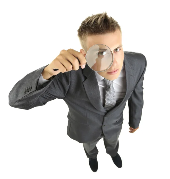 Young businessman looking through magnifying glass isolated on white — Stock Photo, Image