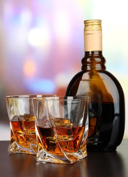 Glass of liquor with bottle, on dark background — Stock Photo, Image