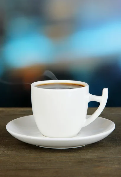 Taza de café sobre mesa de madera sobre fondo brillante — Foto de Stock