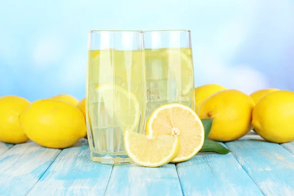 Délicieuse limonade sur table sur fond bleu — Photo