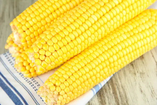 Crude corns on napkin on wooden table — Stock Photo, Image