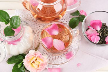 Kettle ve çay gülü peçete ahşap zemin üzerinde gelen