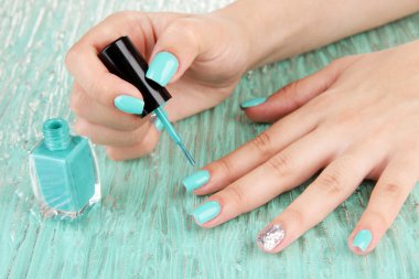 Mavi manikür, renkli arka plan üzerinde elleriyle güzel kadın