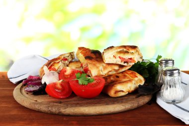 Pizza calzones doğa zemin üzerine ahşap masa peçeteye yakınındaki ahşap tahta üzerinde