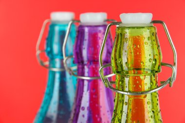 kırmızı bir arka plan üzerinde renkli şişe