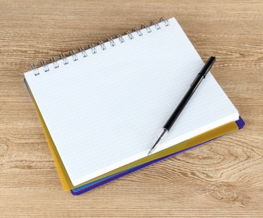 defter ve kalem ahşap masaya