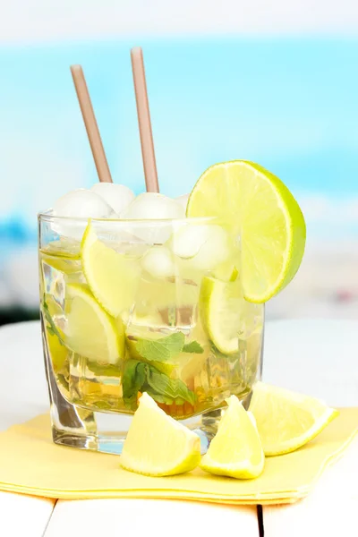 Glas cocktail med lime och mynta på vita träbord på ljus bakgrund — Stockfoto