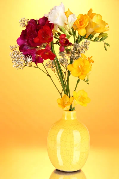 Beau bouquet de freesia en vase sur fond orange — Photo