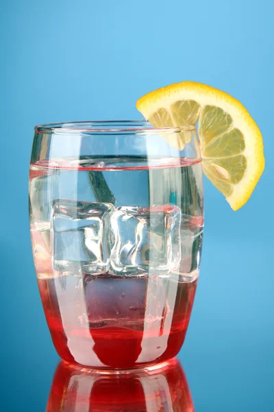 Glas vatten och is på blå bakgrund — Stockfoto