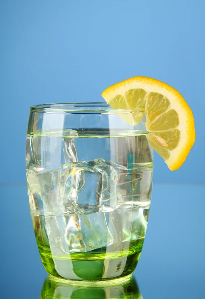 Verre d'eau et de glace sur fond bleu — Photo