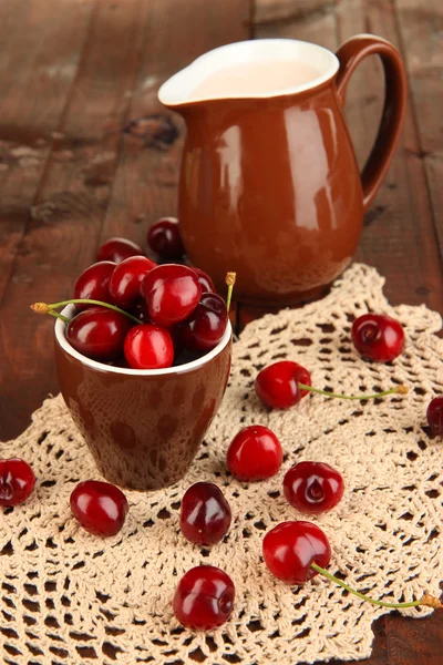 Bagas de cereja vermelhas maduras em xícara na mesa de madeira close-up — Fotografia de Stock