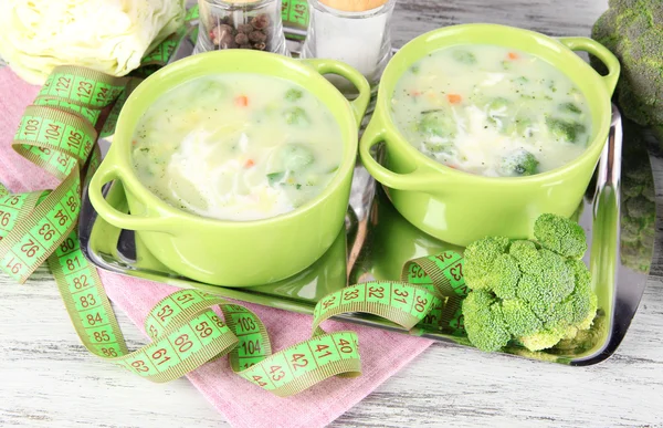 Cabbage soup in plates on metal tray on napkin on wooden table — Stock Photo, Image