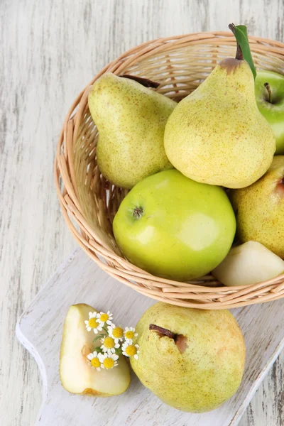 Pears in basket on board on wooden table — Stock Photo, Image