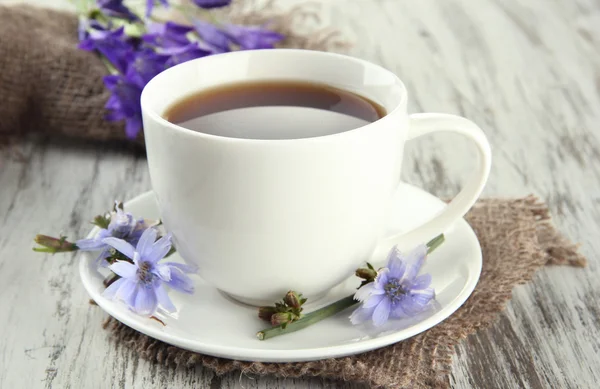 Cup of tea with chicory, on wooden background — Stock Photo, Image