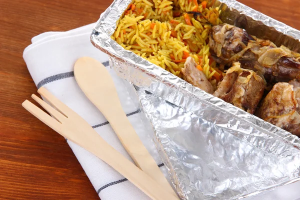 Comida en caja de papel de aluminio sobre servilleta sobre fondo de madera —  Fotos de Stock