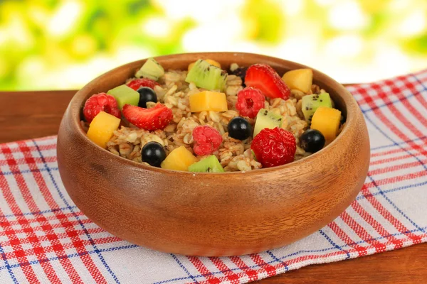 Oatmeal with fruits on table on bright background — Stock Photo, Image