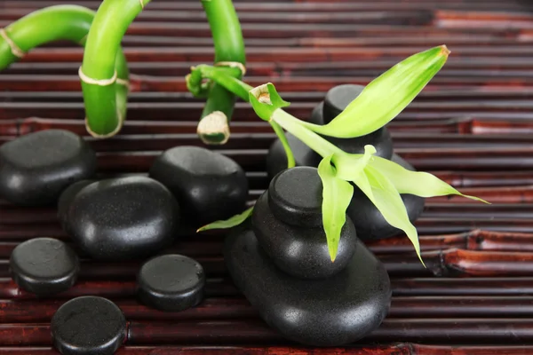 Wellness-Steine und Bambus auf Bambusmatte Hintergrund — Stockfoto