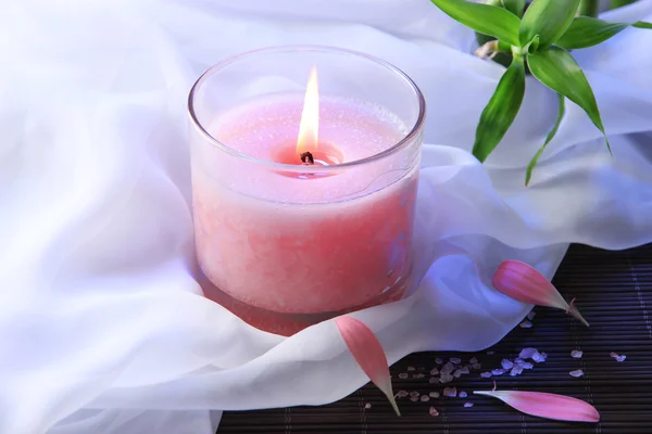 Bella candela rosa su tappetino di bambù — Foto Stock