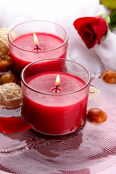Beautiful red candles with flower petals in water — Stock Photo, Image