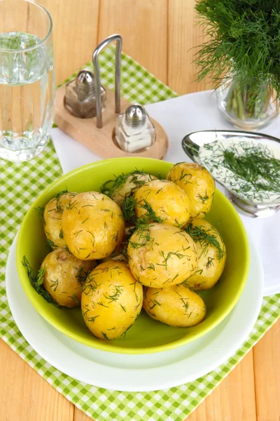 Pommes de terre bouillies sur les plateaux sur les serviettes sur la table en bois — Photo