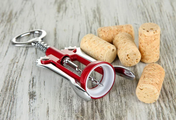 Sacacorchos con tapones de vino sobre mesa de madera —  Fotos de Stock