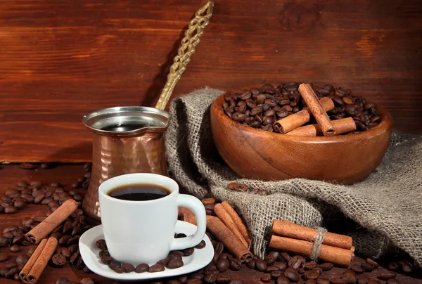 Koffiekopje en metalen turk op houten achtergrond — Stockfoto