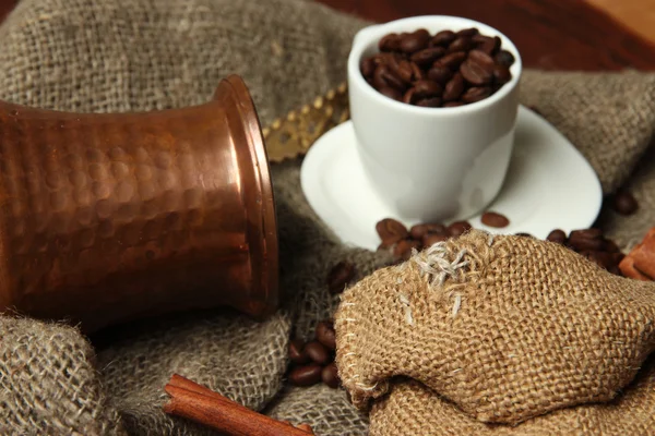 Xícara de café e metal turk no fundo da serapilheira — Fotografia de Stock