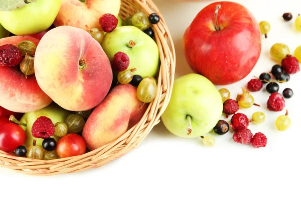 Ποικιλία από ζουμερά φρούτα στο καλάθι λυγαριά και ξύλινο μπολ, απομονωμένα σε λευκό — Φωτογραφία Αρχείου