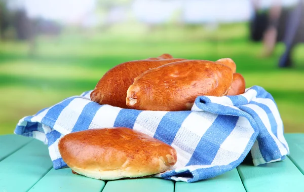 Pasteles recién horneados, sobre mesa de madera, sobre fondo brillante — Foto de Stock