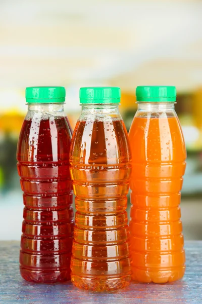 Ürün çeşitliliği ile parlak zemin üzerine lezzetli meyve suyu şişeleri — Stok fotoğraf