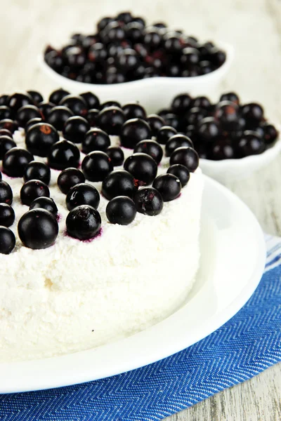 Cheesecake with fresh berries on white plate on wooden table closeup — Stock Photo, Image