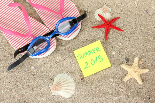 Composition with flip flops, goggles on sand background — Stock Photo, Image