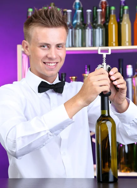 Bartender opens bottle of wine