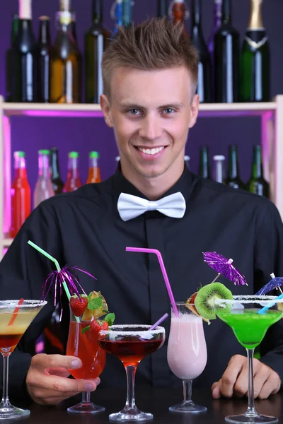 Portrait of handsome barman with different cocktails cocktail, at bar — Stock Photo, Image