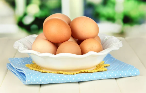 Eggs in plate on wooden table on window background — Stock Photo, Image