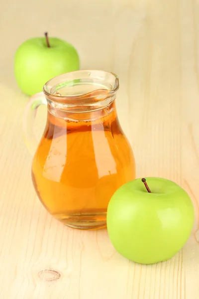 Full jug of apple juice and apple on wooden background Stock Image