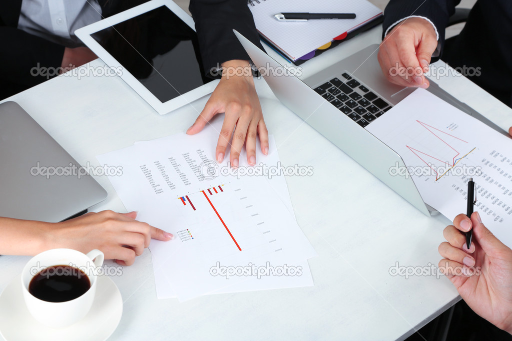 businesspartners hands during discussion of papers close up