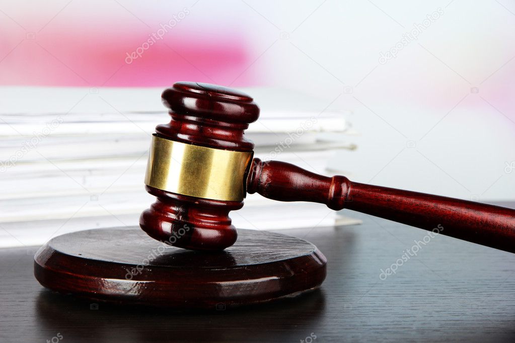 Gavel and documents on table on light background