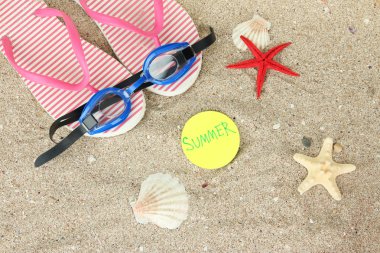 kompozisyon ile flip floplar, kum zemin üzerine koruyucu gözlük