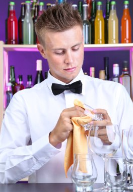 Barmen gözlük iş yerinde siliyor.