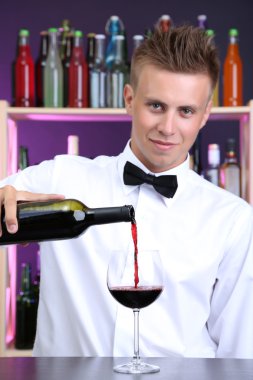 Barmen kırmızı şarap cam içine yağıyor