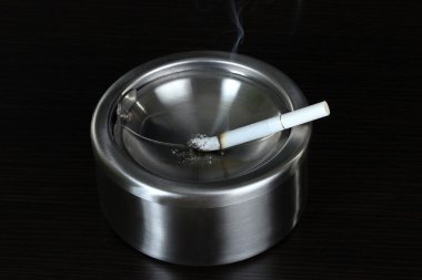 metal kül tablası ile sigara, siyah üzerine izole