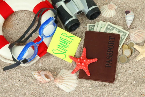 Composition with lifebuoy, goggles, notepad and money, on sand background — Stock Photo, Image