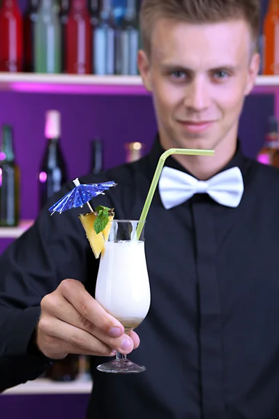 Porträtt av stilig bartender med pina colada cocktail, bar — Stockfoto