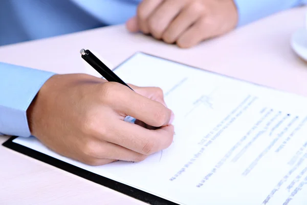 Businessman writing on document in office close-up — Stock Photo, Image