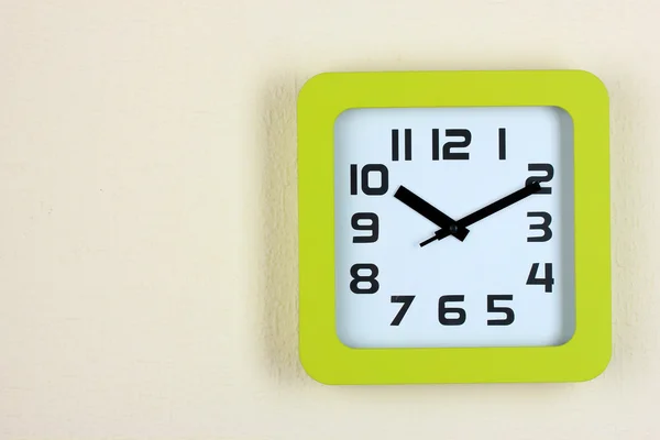 Office clock on color wall background — Stock Photo, Image