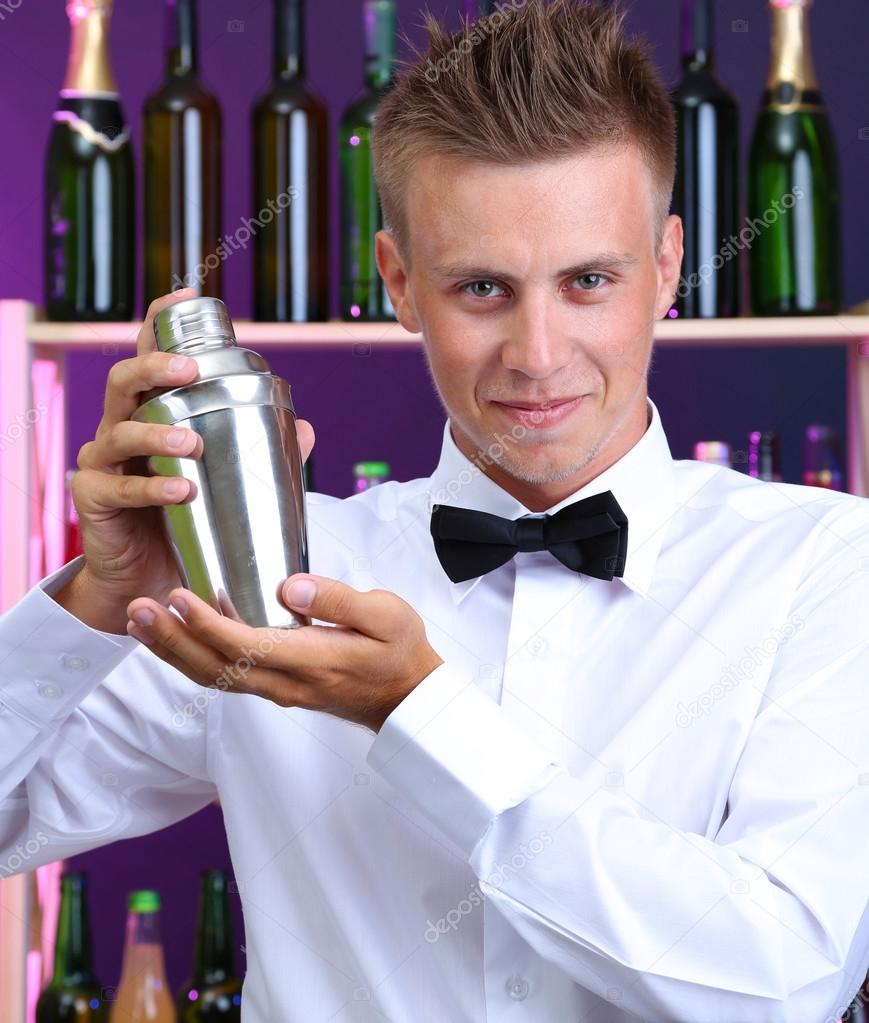 Portrait of handsome barman with shaker, at bar