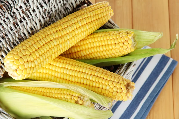 Crude corns in basket on napkin on wooden table — Stock Photo, Image