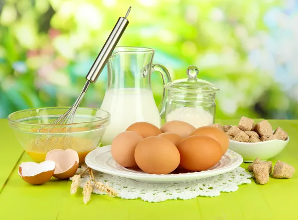 Ingredients for dough on wooden table on natural background — Stock Photo, Image